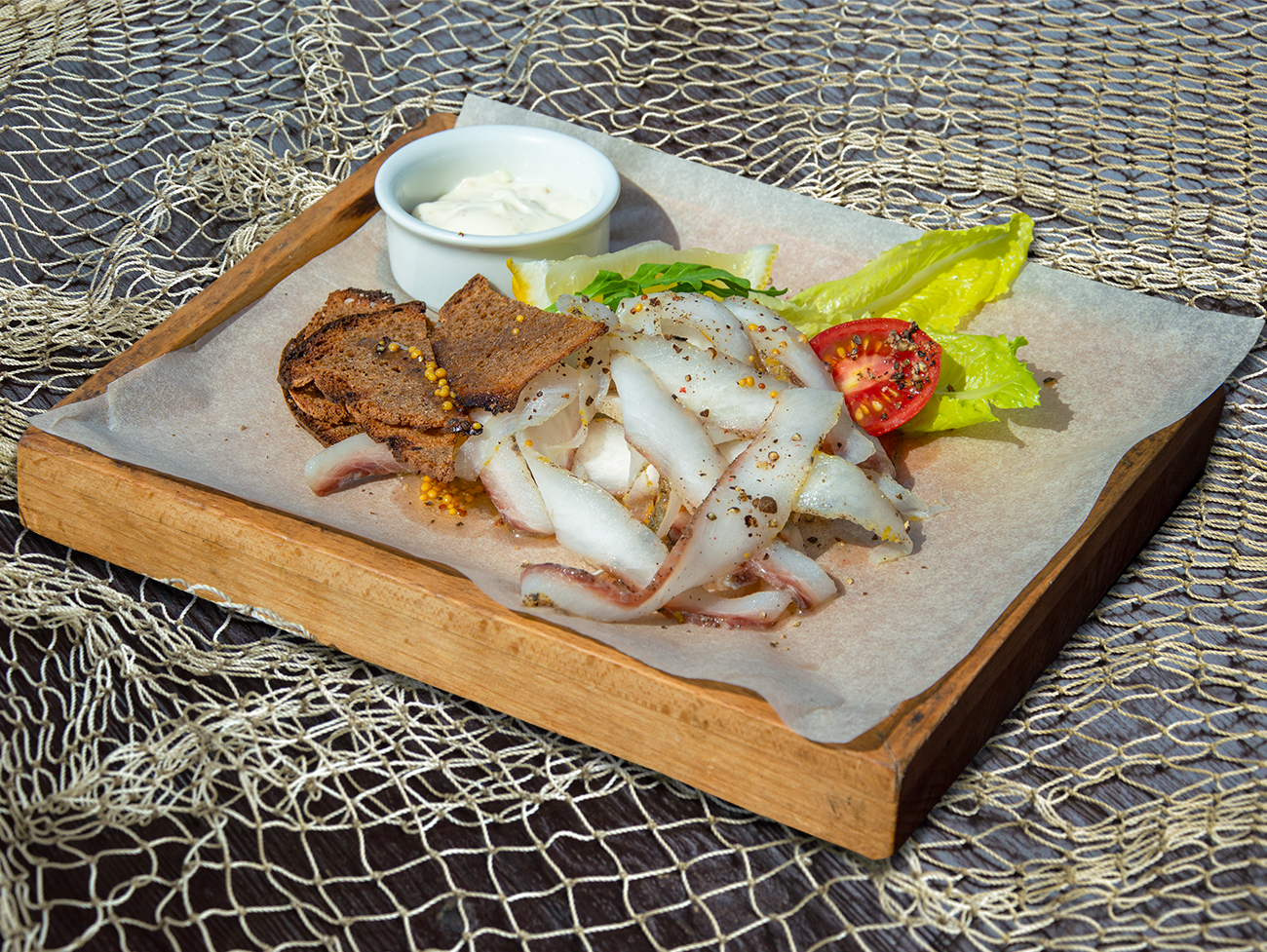Строганина из черноморской рыбы с соусом Айолии гренками